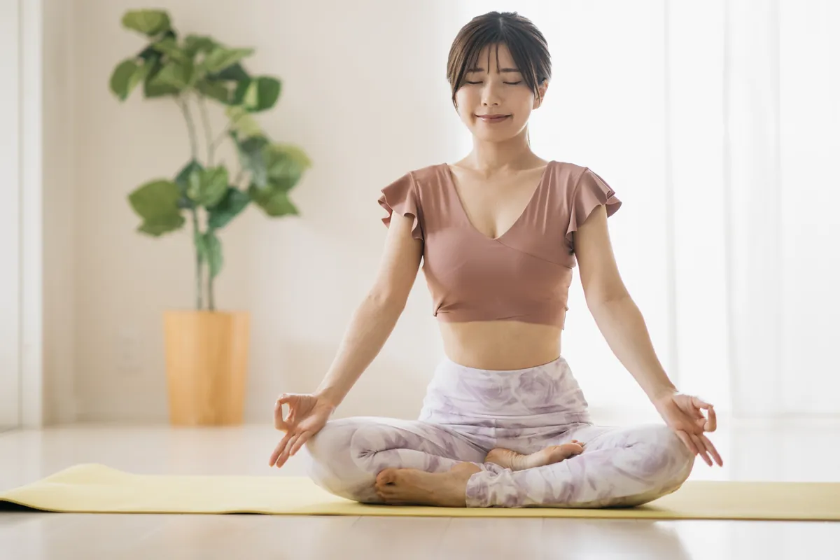 座位で呼吸を整える女性（イメージ）